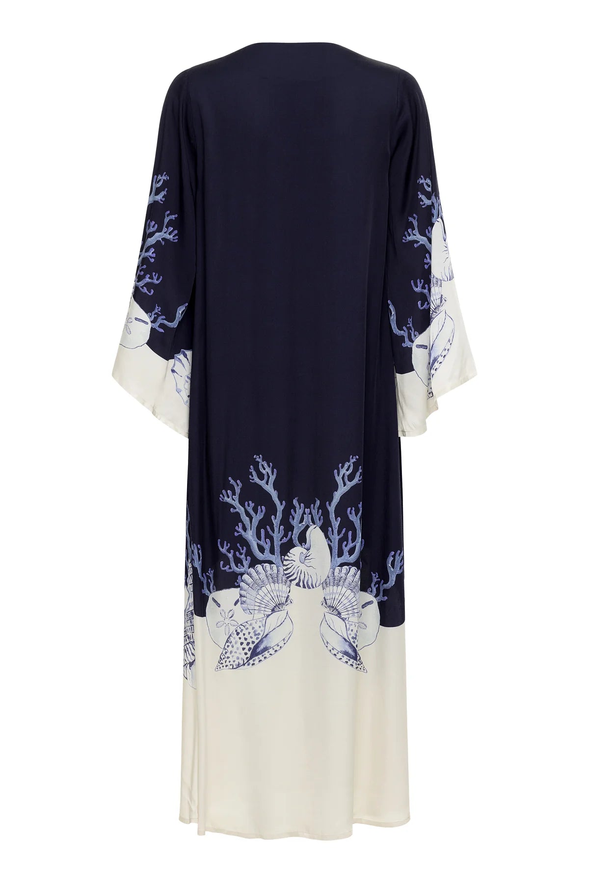 The Lena Kaftan by Carolina K is a long, loose robe with wide sleeves, featuring a navy top and ivory bottom with blue coral and seashell patterns at the hem and cuffs.