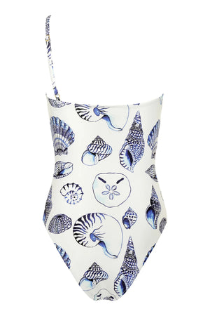 The Maj One Shoulder swimsuit by Carolina K features a white base with blue seashell and marine life prints, inspired by South African artist Felicity Buchanan.