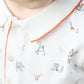 Close-up of a child in a Tartine et Chocolat Baby Boys' and Boys' Robots Illustration Long Sleeved Polo, showing the robot pattern, orange collar trim, and part of the child's face.