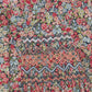 Close-up of the Girls' Liberty Smocked Floral Tunic by Tartine et Chocolat, featuring a colorful floral Liberty print with intricate zigzag smocking—perfect for girls. "Chocolat" label appears in the top left corner.