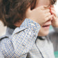 A child in a Tartine et Chocolat Baby Boys' and Boys' Bark at Check Collared Shirt covers their eyes with both hands.