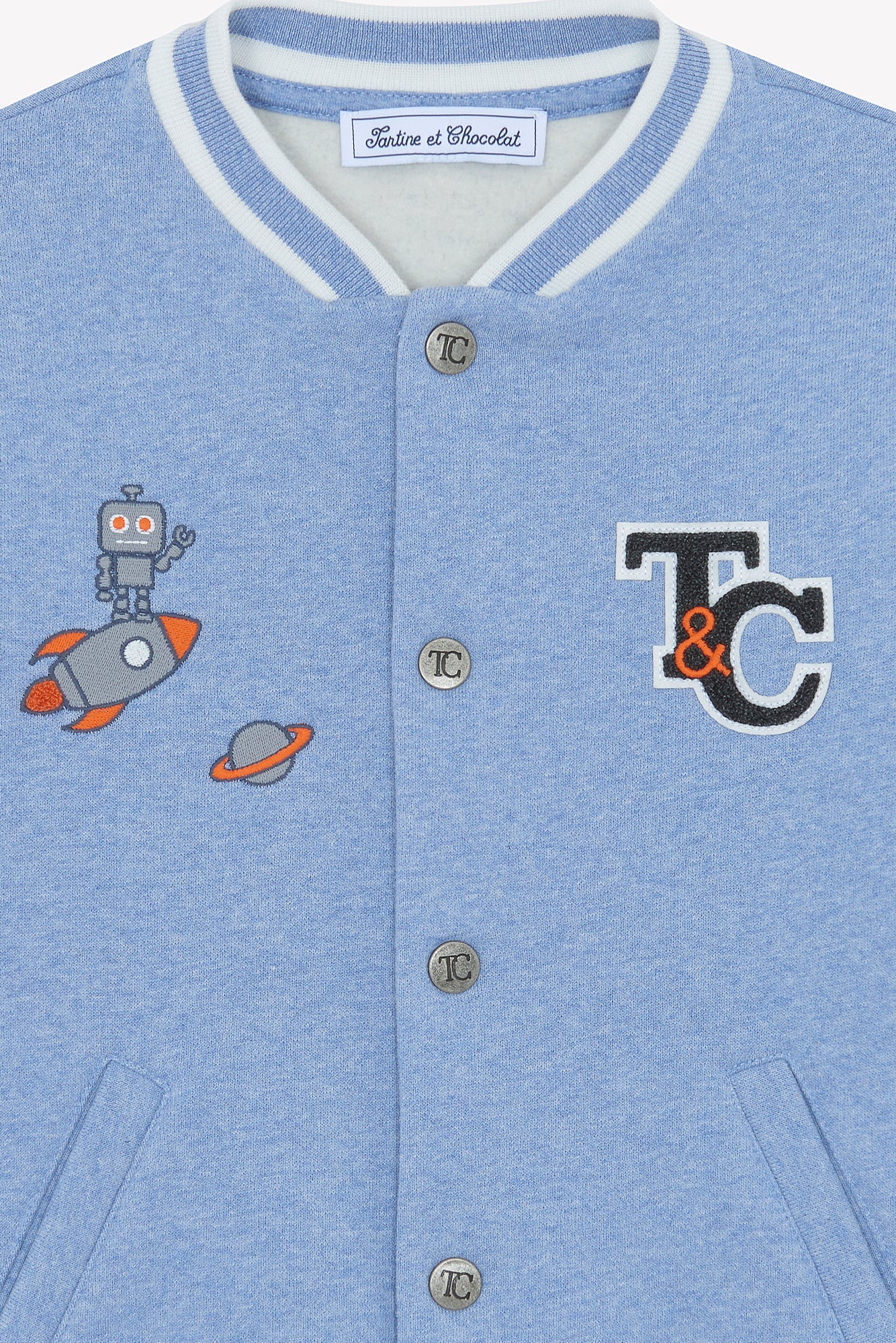 The Tartine et Chocolat Baby Boys' and Boys' Easy Bomber Cardigan features a light blue bomber style, white-striped collar, metallic buttons, and front embroidered patches of a robot, rocket, planet, and "T&C" logo.