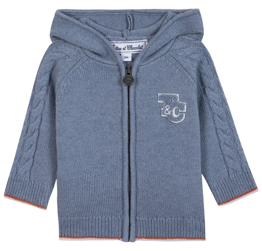The Tartine et Chocolat Baby Boys' and Boys' TC Signature Knit Zip Jacket features a light blue color, hood, zipper closure, cable knit sleeves, and a “T&C” monogram on the left chest for a classic touch.