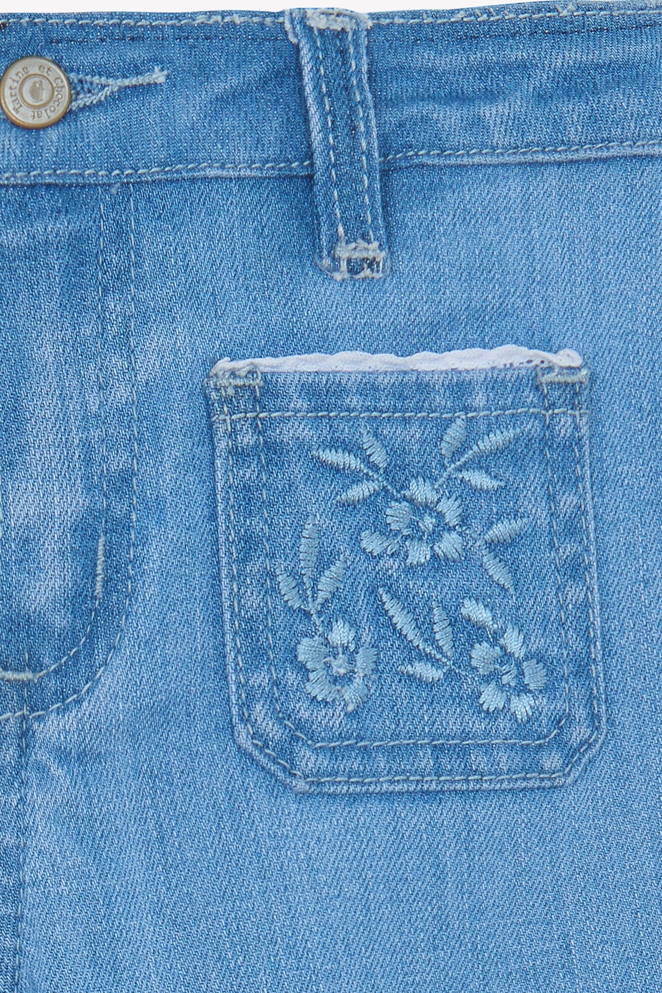 Close-up of Tartine et Chocolat Girls' Blue Flared Embrodery Jeans, highlighting a small pocket with delicate floral embroidery and a visible belt loop.