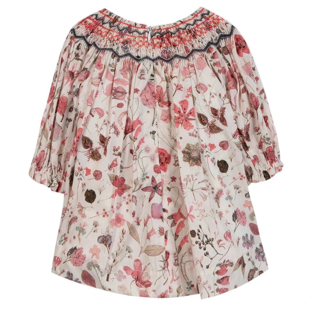 The Tartine et Chocolat Baby Girls' and Girls' Smocked Collar Floral Dress features a pink and red floral print with smocked details at the collar and cuffs, crafted from Liberty fabric.