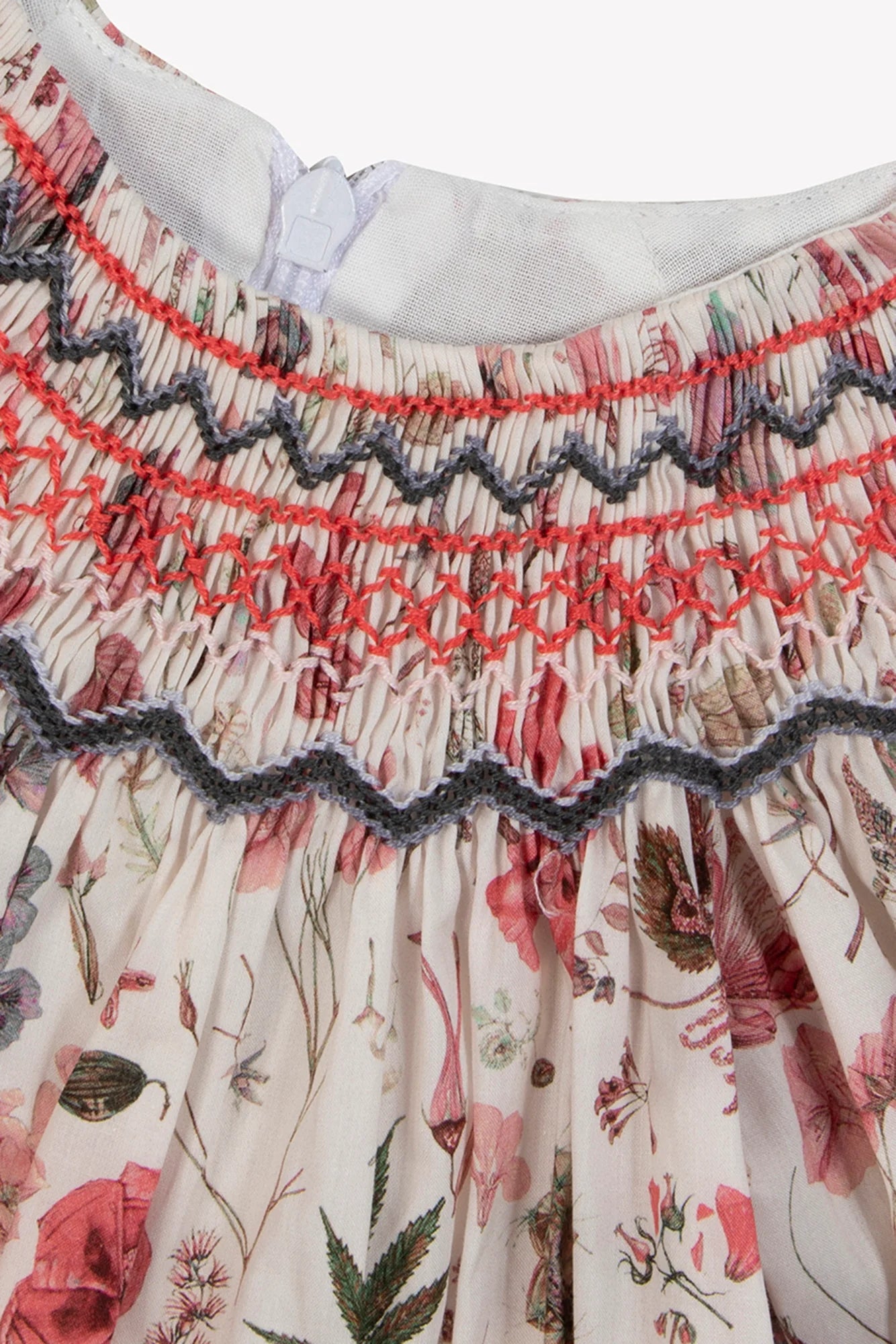 Close-up of the Tartine et Chocolat Baby Girls' and Girls' Smocked Collar Floral Dress, featuring pink and gray smocking at the waist and a white back button.