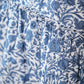 Close-up of the Tartine et Chocolat Girls' Liberty Printed Dress featuring a blue leafy pattern on white fabric, with delicate gathers and refined seams.
