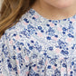 A young girl wears the Tartine et Chocolat Baby Girls' and Girls' Small Flower Blueberry Printed Dress. Only the lower half of her face and upper body are visible.