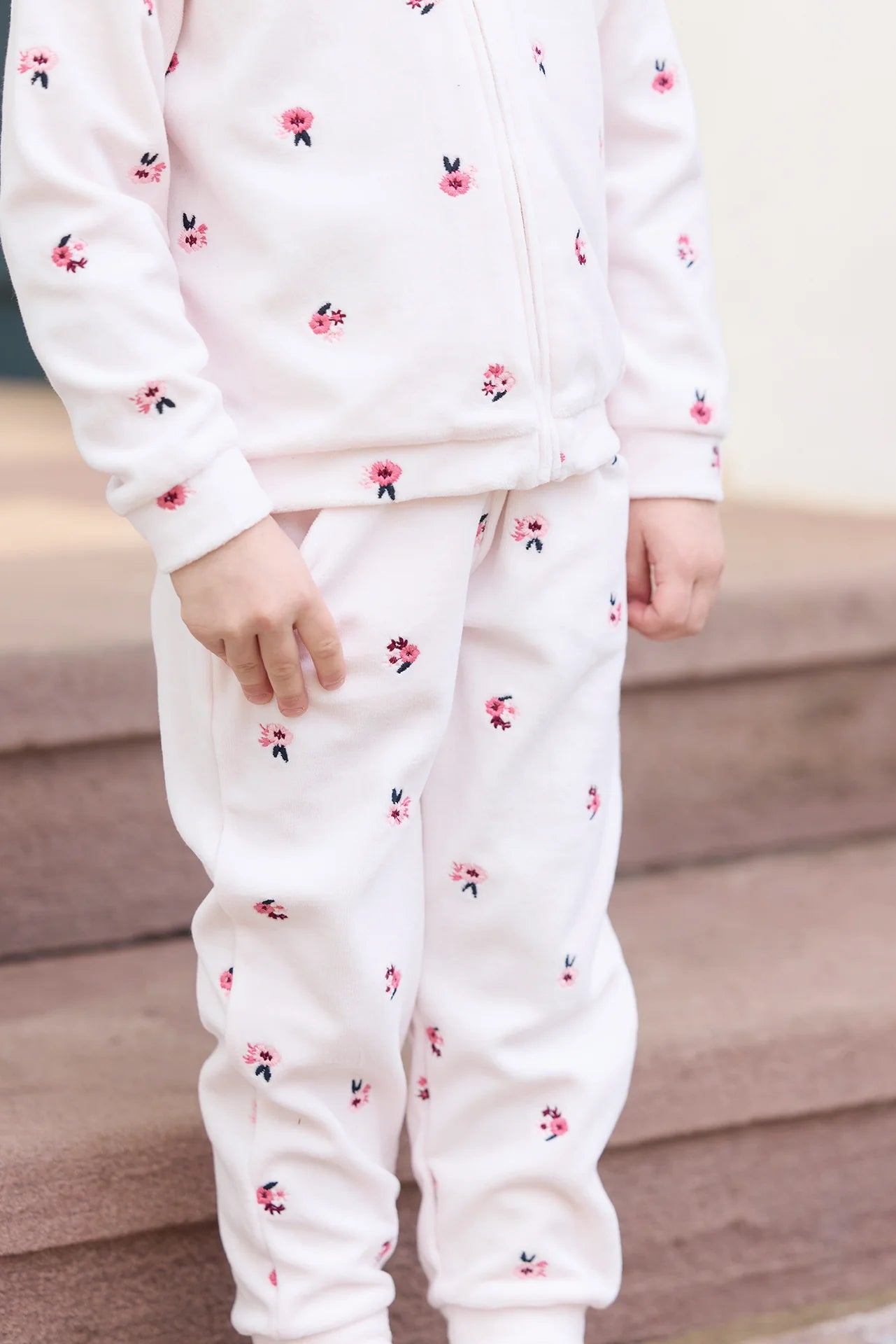 A girl wears the Tartine et Chocolat Baby Girls' and Girls' Velvet Hooded Jogger Set while standing on carpeted steps.