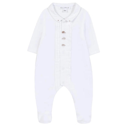 Dress your baby boy in these white long-sleeve footed pajamas from Tartine et Chocolat, featuring a pleated front, silver buttons, a rounded collar, and cute embroidered hedgehogs—Baby Boys' Hedgehog Pajamas.