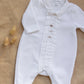 The Tartine et Chocolat Baby Boys' Hedgehog Pajamas—a cozy white long-sleeve onesie with pleated details and embroidered buttons—rests on beige textured fabric beside dried grass stems, perfect for snuggly nights.