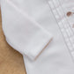 Close-up of Tartine et Chocolat Baby Boys' Hedgehog Pajamas with stitched details and cute embroidered hedgehogs, displayed on a textured beige background.