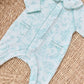 The Tartine et Chocolat Baby Girls' Printed Pajamas in light blue feature a floral Toile de Jouy pattern, Peter Pan collar, and front pockets, shown laid flat on a woven mat.