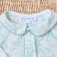 A close-up of Tartine et Chocolat Baby Girls’ Printed Pajamas, pale blue and white with a floral Toile de Jouy-inspired pattern and Peter Pan collar, displayed on a woven surface.