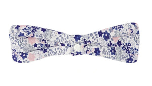 The Tartine et Chocolat Headband features a fabric bowtie with a blue, purple, and pink floral print on white—perfect for babies and beautifully displayed against a white backdrop.