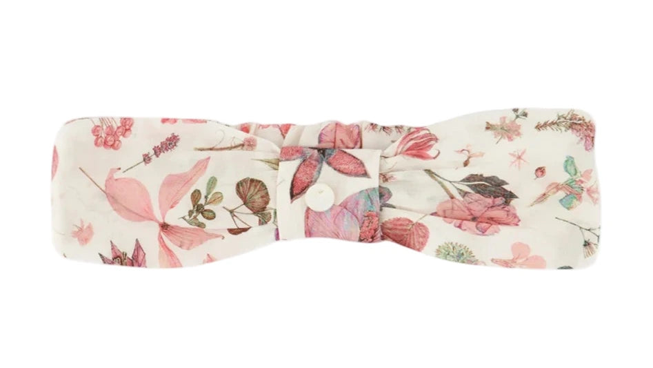 The Tartine et Chocolat Headband is a soft baby accessory in white fabric with a pink and green floral print and a central button detail—a charming printed headband for little ones.