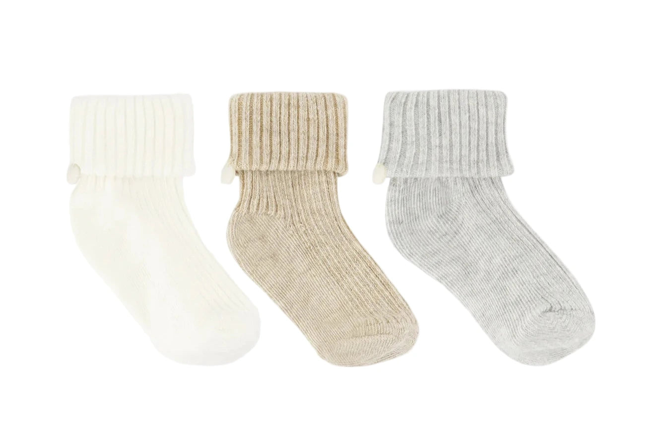 The Tartine et Chocolat Knit Sock 3-Pack features white, beige, and gray ribbed baby socks with fold-over cuffs—an essential addition to any nursery wardrobe.