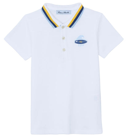 The Boys’ Surfer Polo Shirt by Tartine et Chocolat is a white polo featuring a blue and yellow striped collar and a small embroidered surfboard graphic on the left chest.