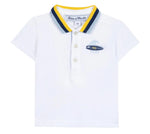 The Tartine et Chocolat Baby Boys’ and Boys’ Polo Shirt is a white cotton polo featuring a blue and yellow striped collar, three buttons, and a small embroidered surfboard logo on the left chest.