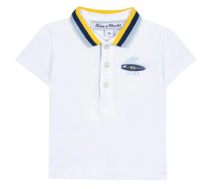 The Tartine et Chocolat Baby Boys’ and Boys’ Polo Shirt is a white cotton polo featuring a blue and yellow striped collar, three buttons, and a small embroidered surfboard logo on the left chest.
