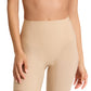 A person models Commando's Zone Smoothing Shorts in nude, paired with a matching bra, from shoulders to mid-thigh, showcasing the smooth silhouette these seamless high-waisted shorts create.
