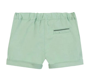 The Tartine et Chocolat Baby Boys’ and Boys’ Short in light green cotton features an elastic waistband, rolled hems, and a small back pocket for practical seaside style, displayed against a white background.