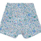 Tartine et Chocolat’s Baby Girls’ and Girls’ Liberty Shorts, summer-ready cotton shorts adorned with a charming floral print featuring pink, blue, and green flowers and leaves on a white background, shown laid flat on a white surface.