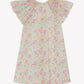 The Tartine et Chocolat Girls’ Liberty Print Dress, shown on a plain white background, is a short-sleeve cotton dress with a pastel floral Liberty print, featuring wide flutter sleeves, a smocked collar, and a loose knee-length fit.