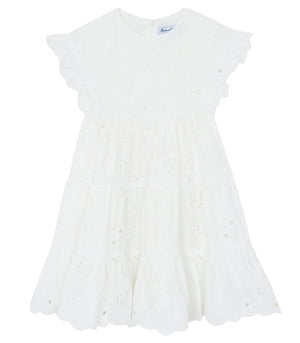 Tartine et Chocolat Girls’ Openwork Dress features delicate eyelet embroidery, ruffled short sleeves, and a scalloped hem. This charming white summer dress is perfect for warm-weather occasions and is displayed on a plain background.