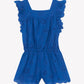 The Tartine et Chocolat Girls’ Openwork Short Jumpsuit features a blue openwork pattern, ruffled flutter sleeves, a square neckline, elastic waistband, and scalloped edges, shown against a white background.