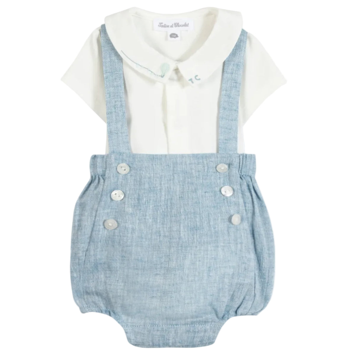 The Tartine et Chocolat Baby Boys’ Pointed Collar Overall Outfit features a crisp white collared shirt paired with attached blue suspender-style shorts adorned with white front buttons and whimsical hot air balloon embroidery for a playful finish.