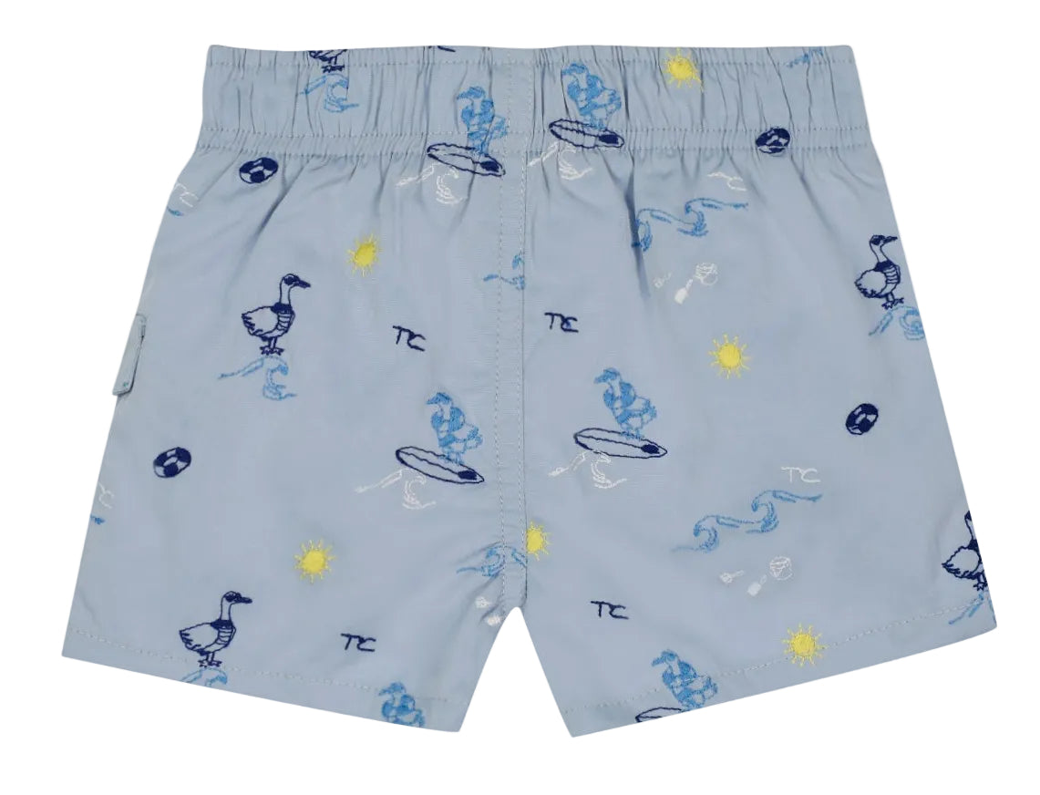 Tartine et Chocolat Baby Boys’ and Boys’ Swim Short in light blue, featuring an elasticated waistband and playful cartoon prints of ducks, surfboards, suns, waves, and beach balls in blue, yellow, and white—ideal for fun-filled days at the beach.