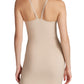 A woman wears the Commando Zone Smoothing Full Slip in beige, featuring a form-fitting design, adjustable straps, and a straight hem that falls just above the knees, seen from the back.