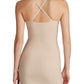 A woman is seen from the back wearing the Commando Zone Smoothing Full Slip, a beige, form-fitting dress with adjustable crisscross straps.