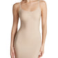 A woman models the Commando Zone Smoothing Full Slip, a beige fitted dress with thin straps and zoned compression, shown from shoulders to mid-thigh against a white background.