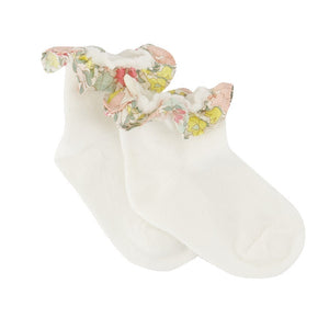 A pair of Tartine et Chocolat Baby Liberty Print Socks in white cotton, featuring a delicate floral ruffled trim around the ankle, displayed on a plain white background. These charming socks add a touch of sweetness to any little one’s outfit.