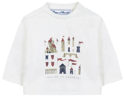 The Tartine et Chocolat Baby Boys’ and Boys’ Castle Print Cotton T-Shirt is a white, long-sleeved top made from soft unbleached cotton, featuring an enchanting castle illustration with towers and red flags, and the “Tartine et Chocolat” logo elegantly written beneath the print.