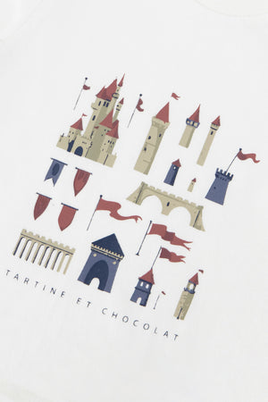 A charming castle graphic featuring towers, arches, and red flags adorns this unbleached cotton T-shirt for baby boys and boys from Tartine et Chocolat, with the brand name printed below.