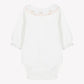 The Tartine et Chocolat Baby Girls’ Ruffled Collar Bodysuit is an ecru cotton long sleeve onesie, adorned with a ruffled floral collar accented by pink trim and delicate embroidered flowers, displayed flat against a plain background.