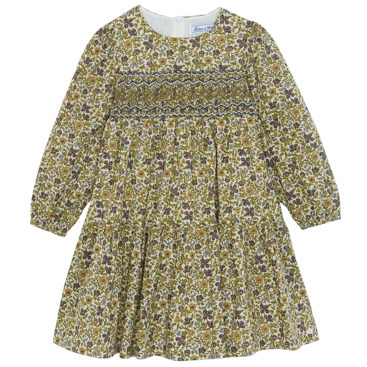 Introducing the Girls’ Liberty Embroidery Round Neck Cotton Dress by Tartine et Chocolat—this long-sleeved dress features a smocked bodice, gathered skirt, and zipper back closure. Its delicate floral embroidery in green, brown, and purple hues on a cream background brings to mind the beauty of an English garden.