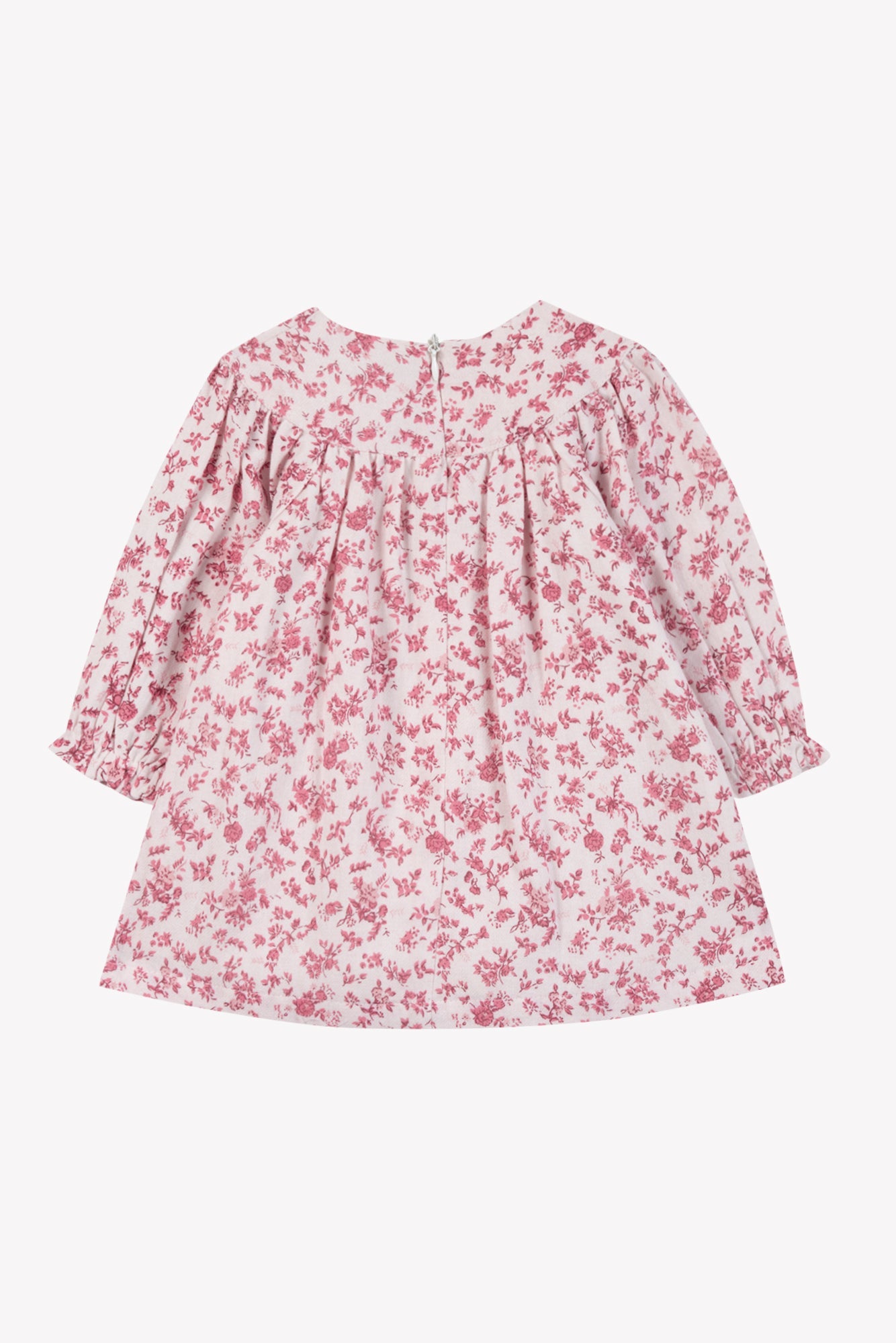 The Girls’ Floral Print Cotton Dress by Tartine et Chocolat is a pink, long-sleeve dress for children, made from soft unbleached cotton. It features a floral print, round neckline, ruffled cuffs, and a back zipper closure. The dress is displayed against a plain white background.