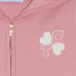 Close-up of the Girls’ Wool Hood Cotton Jogging Suit by Tartine et Chocolat, featuring a pink zip-up hoodie with a gold zipper, white “TC” and heart shapes on the chest, and a “Tartine et Chocolat” label at the neck. This charming piece is part of the Paris Mon Amour kids tracksuit collection, crafted from soft cotton and wool for comfort and style.