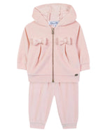 The Tartine et Chocolat Baby Girls’ Jogging Suit Outfit is a light pink toddler hoodie and pants set designed as a cozy tracksuit, featuring a front zipper, hooded jacket, and two decorative bows on the jacket—a charming addition to any baby clothing collection.