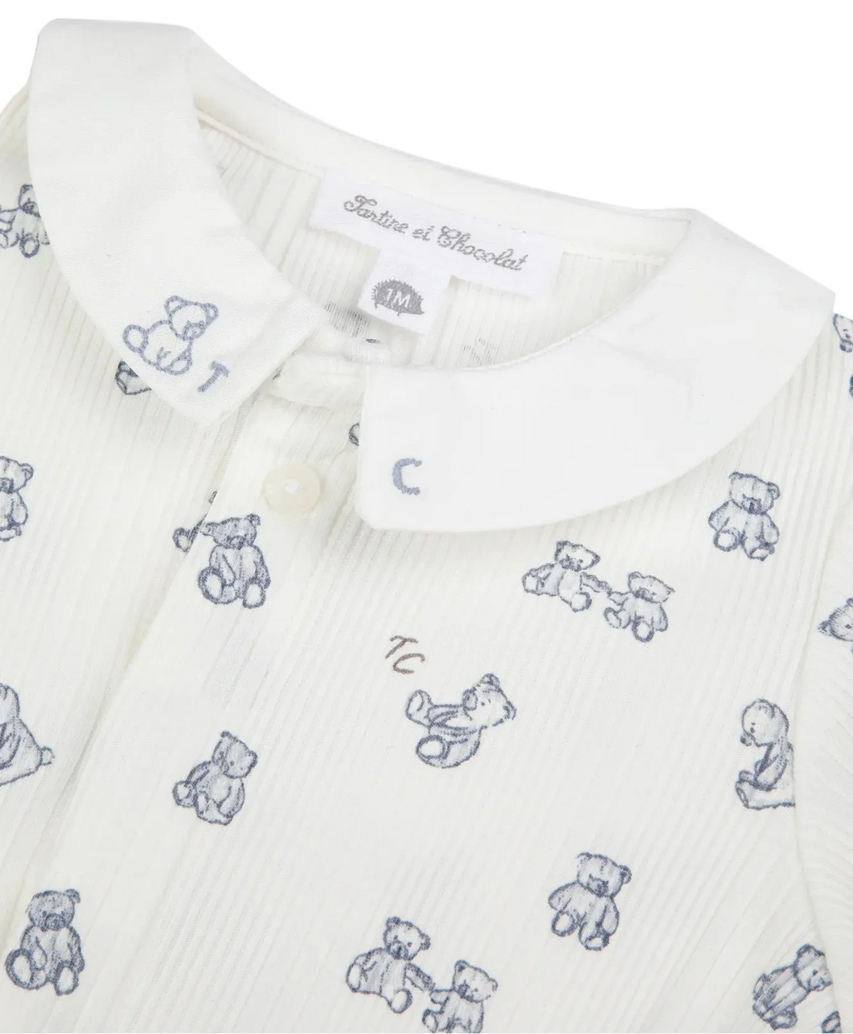 Crafted from soft, unbleached cotton for gentle comfort, the Tartine et Chocolat Baby Boys’ Ribbed Knit Pajama features a classic white design with a rounded collar, small buttons, and charming blue teddy bear motifs printed throughout. Perfect as part of a cozy newborn pajama set.