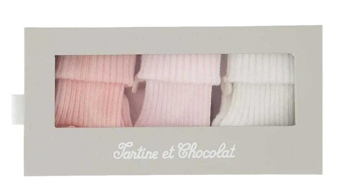 A box labeled “Tartine et Chocolat” contains the Cotton Sock Set, featuring three pairs of ribbed toddler socks in pink, light pink, and white—specially designed for sensitive baby skin and showcased behind a clear window.
