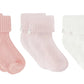 The Cotton Sock Set by Tartine et Chocolat features three pairs of ribbed baby socks in pink, light pink, and white, each adorned with a folded cuff and a delicate side bow. Displayed on a white background, these charming socks are designed to offer both comfort and style for your little one.