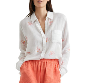 Woman in a Rails Charli Shirt with red floral embroidered pattern, paired with a coral pleated skirt, cropped at the torso.