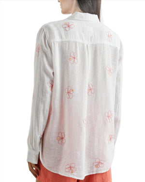 Rear view of a woman wearing a Rails Charli Shirt with pink floral embroidered pattern, standing against a plain background.