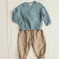 A Cozmo Baby Boys’ Chipre Quilted Sweatshirt in blue, featuring long sleeves and a chest pocket, paired with brown striped pants with patch pockets, both displayed flat on a white background.