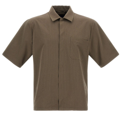 The Herno Seersucker Camp Shirt is a short-sleeved, collared, olive-brown shirt with a single chest pocket and versatile cut, displayed against a white background.